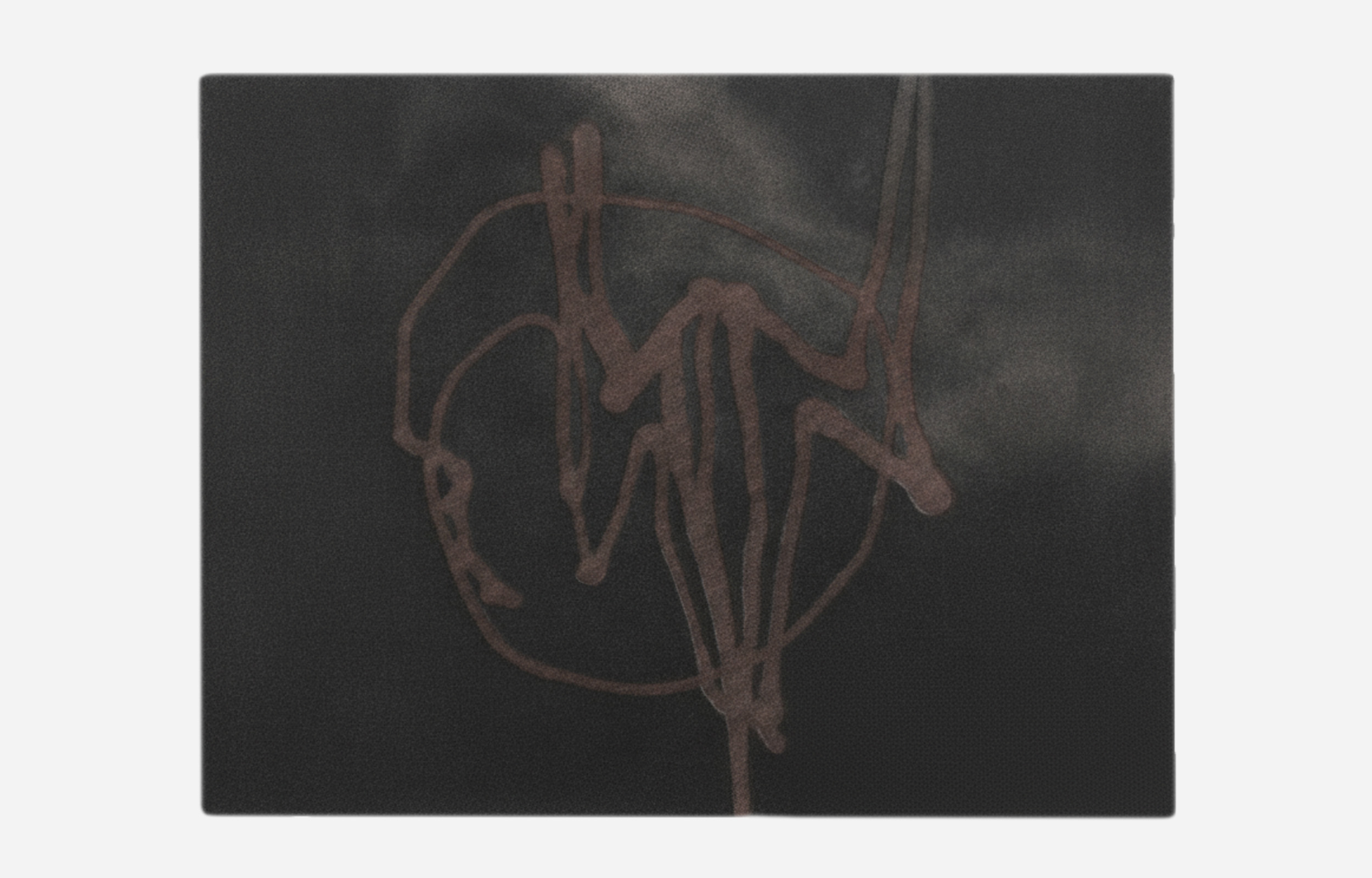 Abstract hand-tufted rug in charcoal black and deep gray with thin, freeform copper or rust-colored scribbled line art. Minimalist dark statement rug.